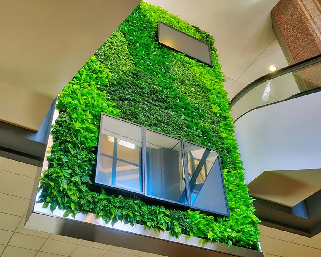 A striking living wall installation alongside an escalator in a commercial building.