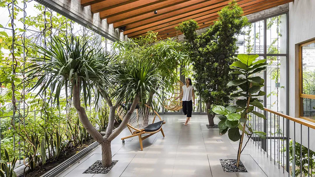 This grand example of biophilic design displays a nature-immersive experience of plant life, stones, and natural light.