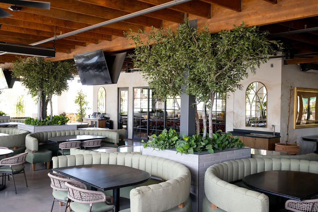 Blanco Cocina Cantina in Paradise Valley showcases hand-crafted custom faux trees that are UV-protected, surrounded by natural pothos for beautiful outdoor seating.